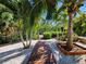 Backyard walkway through palm trees and manicured landscaping offers a secluded retreat at 2408 Nassau St, Sarasota, FL 34231
