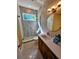 This modern bathroom features a walk-in shower, floating vanity, and a round mirror with stylish lighting at 2408 Nassau St, Sarasota, FL 34231