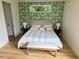 Cozy bedroom featuring a queen-size bed, botanical wallpaper, and light wood floors at 2408 Nassau St, Sarasota, FL 34231