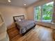 Comfortable bedroom with a plush bed, hardwood floors, and a large window offering serene backyard views at 2408 Nassau St, Sarasota, FL 34231