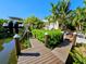 Wooden dock with water access features manicured hedges leading towards house at 2408 Nassau St, Sarasota, FL 34231