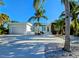 Modern home with lush landscaping, a paver driveway, and a two-car garage on a sunny day at 2408 Nassau St, Sarasota, FL 34231