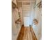 Spacious walk-in closet featuring custom shelving, drawers, hanging rods and attractive hardwood flooring at 2408 Nassau St, Sarasota, FL 34231