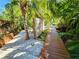 Wooden walkway lined with white stone leads through lush landscaping and tropical foliage at 2408 Nassau St, Sarasota, FL 34231