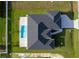 Aerial view of a single-Gathering home featuring a pool, black roof, and manicured lawn at 9257 King Hill St, Port Charlotte, FL 33981