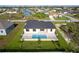 Aerial view of a home with a backyard pool, patio, and well-maintained lawn at 9257 King Hill St, Port Charlotte, FL 33981
