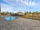 In-ground swimming pool with brick-paver deck and black fence at 9257 King Hill St, Port Charlotte, FL 33981