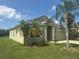 Charming one-story home with a two-car garage, green lawn, and swaying palm trees at 1452 Crazy Horse Dr, Lutz, FL 33559