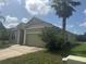 Inviting one-story home featuring a two-car garage, well-kept lawn, and a mature palm tree at 1452 Crazy Horse Dr, Lutz, FL 33559