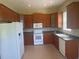 Functional kitchen with wood cabinetry, white appliances, and ample countertop space at 1452 Crazy Horse Dr, Lutz, FL 33559