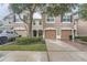 Two-story townhome with brown shutters, a garage, and a well-manicured lawn at 26622 Castleview Way, Wesley Chapel, FL 33544