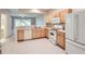 Bright kitchen features white appliances, tile floors, and wood cabinets at 26622 Castleview Way, Wesley Chapel, FL 33544