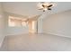 Open living room with tile floors and access to kitchen and staircase at 26622 Castleview Way, Wesley Chapel, FL 33544