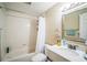 Bright bathroom features a tub with white subway tile and a vanity with framed mirror at 1711 E Sewaha St, Tampa, FL 33612
