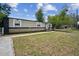 Charming home featuring a spacious front lawn and a covered entrance, creating a welcoming curb appeal at 1711 E Sewaha St, Tampa, FL 33612