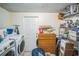 Functional laundry room with side by side washer and dryer, storage cabinets and shelves at 1711 E Sewaha St, Tampa, FL 33612