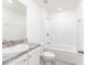 Bright bathroom featuring a shower-tub combo, granite countertops, and modern fixtures at 23461 Wickens Ave, Port Charlotte, FL 33980