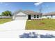 Charming single-story home with a two-car garage, new lawn, and a concrete driveway at 3124 N Chamberlain Blvd, North Port, FL 34286