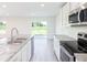 The kitchen shows stainless steel appliances, sleek granite countertops, and a lovely breakfast nook at 3124 N Chamberlain Blvd, North Port, FL 34286