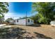 Spacious backyard with a mix of grass and shaded areas, including mature trees at 5907 Sussex Ct, Tampa, FL 33615