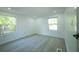 Bright bedroom featuring hardwood floors, recessed lighting, and two windows at 5907 Sussex Ct, Tampa, FL 33615
