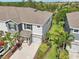 Aerial view of a two-story home with an attached garage, a well-manicured lawn, and mature trees at 8661 Daydream St, Sarasota, FL 34238