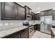 Modern kitchen featuring stainless steel appliances, dark wood cabinets, and granite countertops at 8661 Daydream St, Sarasota, FL 34238