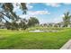 Scenic view of community pond with lush green grass and landscaping at 8661 Daydream St, Sarasota, FL 34238