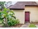 Charming townhome featuring a deep red front door and lush tropical landscaping at 5641 Ashley Oaks Dr # 39, Tampa, FL 33617