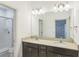 Elegant bathroom features double sink vanity with quartz countertop and walk-in glass shower at 6204 Camino Dr, Apollo Beach, FL 33572
