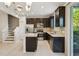 Modern kitchen with dark cabinetry, stainless appliances, island with quartz countertops, and tile flooring at 6204 Camino Dr, Apollo Beach, FL 33572