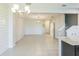Bright, open-concept living space featuring stylish lighting and a modern kitchen with stainless appliances at 6204 Camino Dr, Apollo Beach, FL 33572
