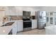 Bright white kitchen features stainless appliances and white cabinets at 6210 Sun Blvd # 206, St Petersburg, FL 33715