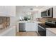 Kitchen overlooking the living room with stainless appliances and white cabinets at 6210 Sun Blvd # 206, St Petersburg, FL 33715
