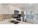 Bright white kitchen features stainless appliances and white cabinets at 6210 Sun Blvd # 206, St Petersburg, FL 33715