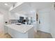 Bright white kitchen features stainless appliances and a breakfast bar with quartz countertop at 6210 Sun Blvd # 206, St Petersburg, FL 33715
