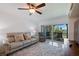 Relaxing living room with plush sofa, patterned armchair, and balcony overlooking lush scenery at 6210 Sun Blvd # 206, St Petersburg, FL 33715