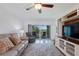 Bright living room boasts a comfortable sofa, TV, built-ins, and scenic balcony access at 6210 Sun Blvd # 206, St Petersburg, FL 33715