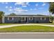 Charming single story home featuring a manicured lawn, neutral paint, blue front door, and white trimmed windows at 1035 S Duncan Ave, Clearwater, FL 33756