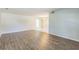 Spacious living room with wood-look flooring and neutral paint; opens to dining area with tile floors at 1035 S Duncan Ave, Clearwater, FL 33756
