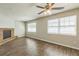 Bright living room featuring a ceiling fan, hardwood floors, and a charming brick fireplace at 1035 S Duncan Ave, Clearwater, FL 33756