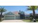Charming one-story home featuring a three-car garage, manicured lawn, and mature palm trees at 1829 Mira Lago Cir, Ruskin, FL 33570