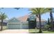 Charming one-story home featuring a three-car garage, manicured lawn, and mature palm trees at 1829 Mira Lago Cir, Ruskin, FL 33570