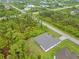 An aerial view displays a home with a lush green lawn, set amongst a backdrop of dense wooded areas at 14256 Salvatierra Ln, Port Charlotte, FL 33981