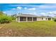 Exterior view of home with a screened lanai overlooking a large lawn at 14256 Salvatierra Ln, Port Charlotte, FL 33981