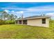 Expansive backyard with lush lawn, view of screened-in patio and home exterior at 14256 Salvatierra Ln, Port Charlotte, FL 33981