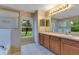 Bathroom featuring double sinks, a walk-in shower, and a garden tub with large window at 14256 Salvatierra Ln, Port Charlotte, FL 33981