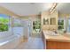 Bright bathroom featuring double sinks, garden tub, and glass enclosed shower at 14256 Salvatierra Ln, Port Charlotte, FL 33981