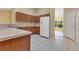 Well-lit kitchen featuring wood cabinets, neutral countertops, and a large refrigerator at 14256 Salvatierra Ln, Port Charlotte, FL 33981