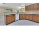 Kitchen boasts wood cabinets, tile flooring, and a breakfast bar overlooking living room at 14256 Salvatierra Ln, Port Charlotte, FL 33981